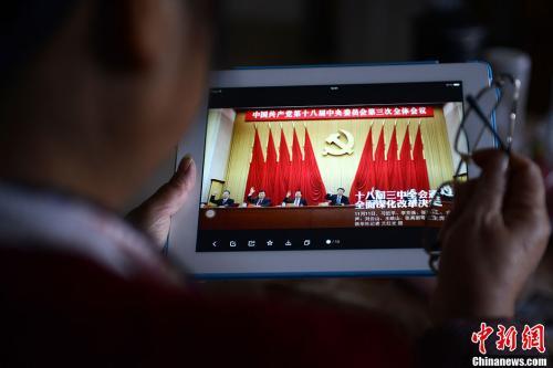 資料圖：一位網(wǎng)友用平板電腦瀏覽有關(guān)中國共產(chǎn)黨十八屆三中全會(huì)的報(bào)道。<a target=